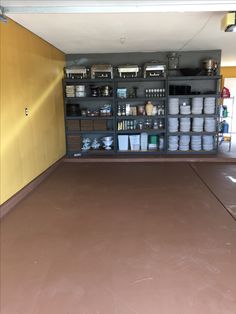 the inside of a storage room with various items on shelves and containers in bins