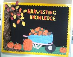 a bulletin board with pumpkins and a wheelbarrow