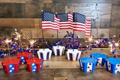 patriotic cupcakes with sparklers and american flags on them are ready for the fourth of july