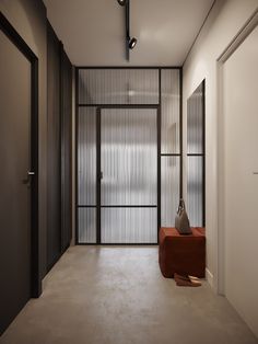 an empty hallway with a red bench in the middle and sliding glass doors on either side