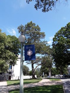 a street light with a blue sign hanging off the side of it's pole