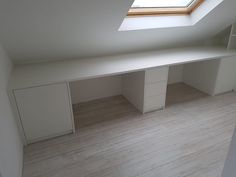 an empty room with white cabinets and a skylight