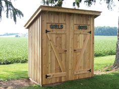 a wooden shed with two doors on the side and girls written on the front door