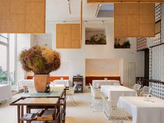 an empty restaurant with white tables and chairs