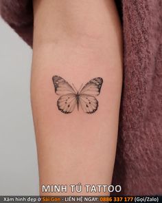 a small butterfly tattoo on the left inner arm and shoulder, which is black and white