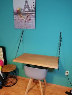 a room with blue walls and a wooden table in the middle, hanging from chains