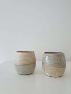 two white and grey bowls sitting next to each other