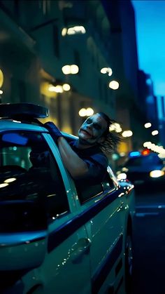 a man leaning out the window of a car at night with his head hanging out