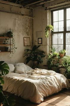 an unmade bed sitting in a bedroom next to a window filled with potted plants