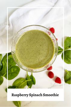 raspberry spinach smoothie in a glass bowl with basil leaves around it