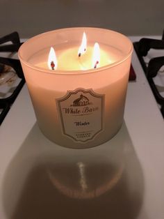 a lit candle sitting on top of a stove