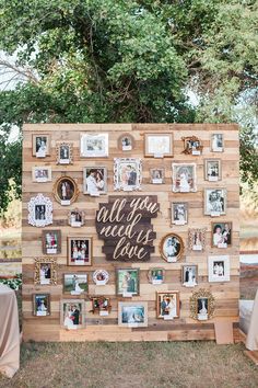 an old pallet is used as a backdrop for a wedding photo display with photos and the words all you need is love