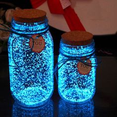 two mason jars with tags on them sitting on a table