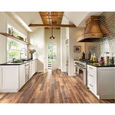 an open kitchen with white cabinets and wood flooring on the walls is pictured in this image