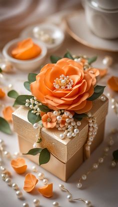 an orange flower sitting on top of a wooden box next to pearls and other items