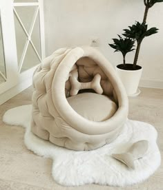 a white dog bed with a plant in the corner