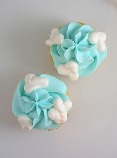 two cupcakes with blue frosting and white decorations