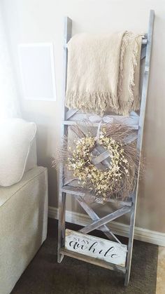 an old ladder is used as a shelf for wreaths and other decorative items in this living room