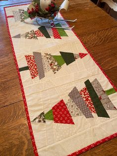 a quilted table runner on top of a wooden table