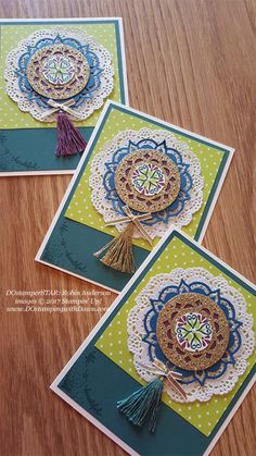 three cards with tassels and doily on them sitting on a table next to each other