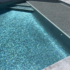 an empty swimming pool with blue water and no one in it at the end,