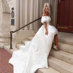 a woman in a white wedding dress sitting on some steps