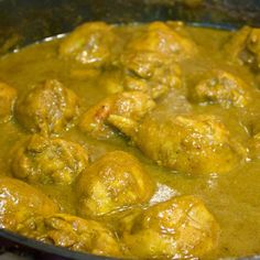 meatballs and gravy are being cooked in a skillet