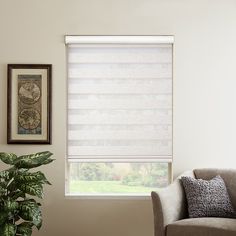 a living room with a chair and window covered in blinds