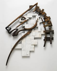 a horse head made out of wooden blocks and metal pieces on a white surface with the word'art'written below it