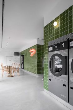 a washer and dryer in a room with green tiles