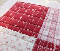 red and white quilted table runner on the floor