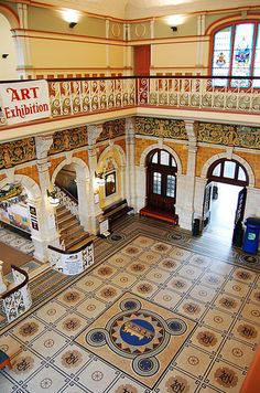 an aerial view of the inside of a building with tiled floors and walls, windows, and staircases