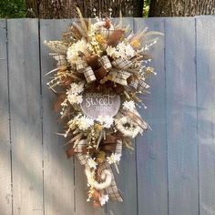 a wreath hanging on the side of a wooden fence