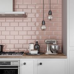 a kitchen with pink tiles on the wall and white cupboards next to an oven