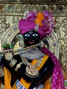 an idol is displayed in front of a gold wall