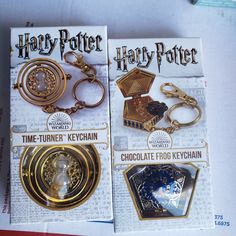 two harry potter keychains are sitting on top of a newspaper with other items