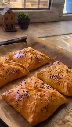 four pieces of bread sitting on top of a baking sheet in front of a window