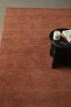 a coffee table with a book and candle on it