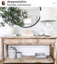 a wooden table sitting under a mirror next to a stair case