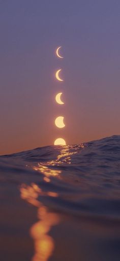 the moon is rising over the ocean as it reflects in the water's surface