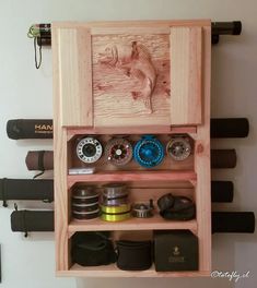 a wooden shelf filled with lots of different types of tools and gadgets hanging on the wall