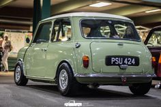 an old green car parked in a parking garage