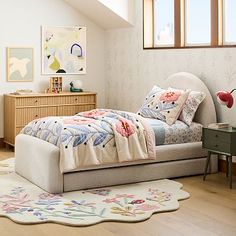 a bedroom with a bed, dresser and rug in the corner next to it is an attic window