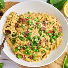 a white bowl filled with pasta and peas