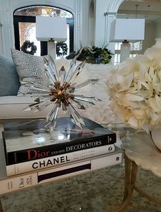 a living room filled with furniture and flowers on top of each bookend, next to a coffee table