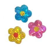 three different colored plastic flowers on a white background