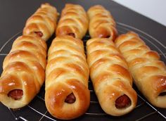 hotdogs wrapped in bread are sitting on a cooling rack, ready to be eaten