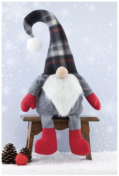 a stuffed gnome sitting on top of a wooden bench next to a pine cone and snowflakes