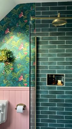 a bathroom with pink and blue walls, green tiles and a gold faucet