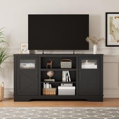 a flat screen tv sitting on top of a wooden entertainment center